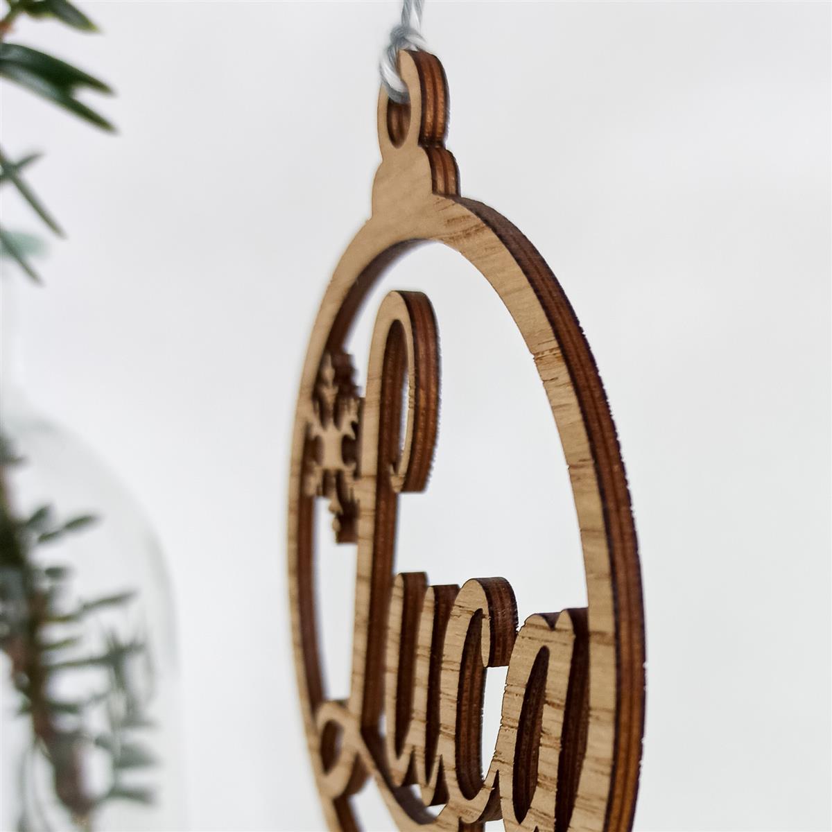 Detailansicht von Kugelanhänger aus Mehrschichtholz mit Name und Schneeflocke